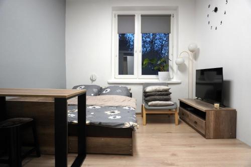 1 dormitorio con cama, escritorio y ventana en Apartament Chorzów Centrum Wróblewskiego, en Chorzów