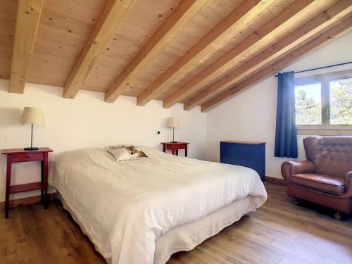 a bedroom with a white bed and a chair at Le Vivier in Saint-Gervais-les-Bains