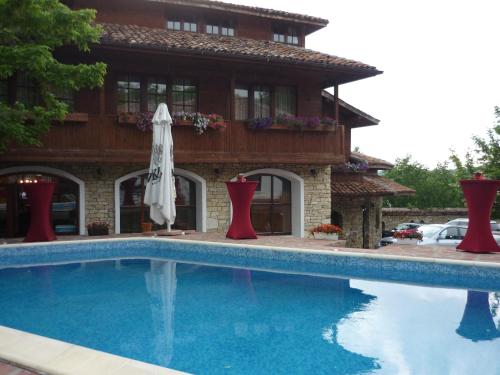 a house with a swimming pool in front of a house at Hotel Izvora in Arbanasi