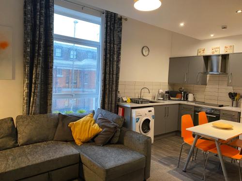 a living room with a couch and a kitchen at Mia's Place Chester in Chester