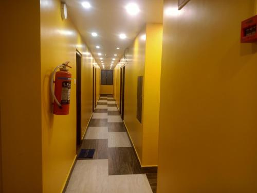 a hallway with yellow walls and a fire hydrant at Hotel Western Park in Port Blair