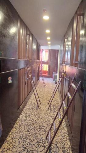 a room with a hallway with wooden doors and a floor at Petra inbox Hostel in Wadi Musa