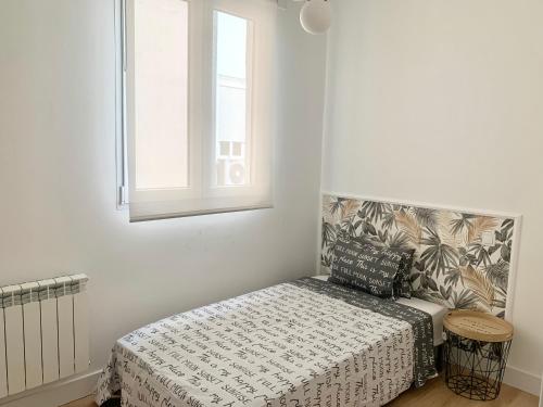 a small bedroom with a bed and a window at Piso recien reformado, junto a Gran Via in Madrid