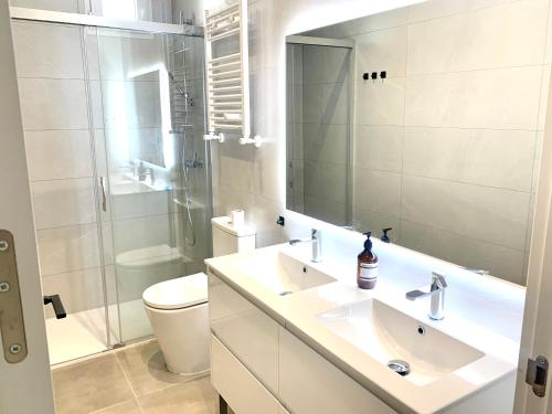 a bathroom with a sink and a toilet and a mirror at Piso recien reformado, junto a Gran Via in Madrid
