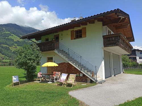 ein Haus mit einem Tisch und Stühlen davor in der Unterkunft Ferienwohnung Zillertaler Alpenblick in Zell am Ziller