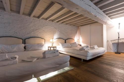 フィレンツェにあるSanta Croce Loftのレンガの壁、ベッド2台が備わるベッドルーム1室が備わります。
