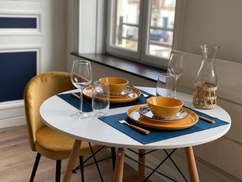 une table avec des assiettes et des verres à vin dessus dans l'établissement Le Bluemoon, studio de charme refait à neuf, à Boulogne-sur-Mer