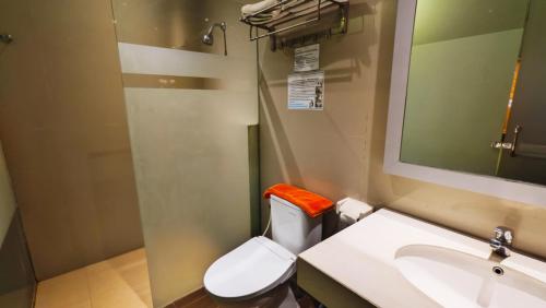 W łazience znajduje się toaleta, umywalka i lustro. w obiekcie Odaita Hotel Pamekasan Madura w mieście Pademabu