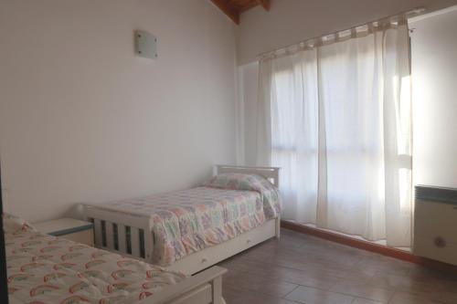 a bedroom with two beds and a window at Casa de Playa in Puerto Madryn
