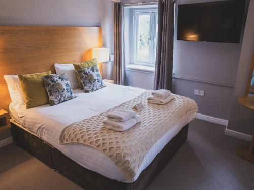 a bedroom with a bed with towels on it at Crossways in Wells