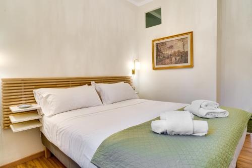a bedroom with a large white bed with towels on it at San Gottardo Suites - Bamboo House in Milan