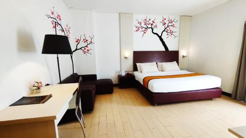 Pokój hotelowy z łóżkiem i biurkiem w obiekcie Odaita Hotel Pamekasan Madura w mieście Pademabu