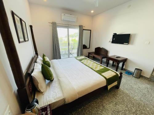 a bedroom with a bed and a desk and a television at Krishna kottage A Boutique Home Stay in Udaipur