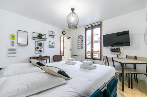 1 dormitorio con cama, mesa y TV en MBA Splendide Appart Diderot 2 - Proche Vincennes, en Montreuil
