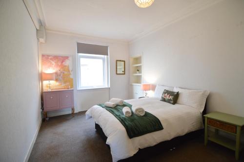 a bedroom with a bed with two towels on it at Two Bedroom Flat with Sea Views! in Fife