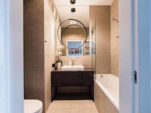 un baño con lavabo y espejo en Warsaw Aparthotel, en Varsovia