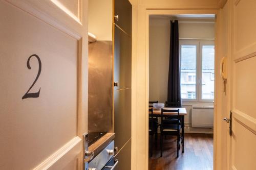 Cette chambre comprend une cuisine avec une table et une porte. dans l'établissement Le Saint Louis 2 Cœur Ville bord de Loire commerces à pied, à Gien