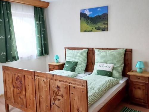 a bedroom with a bed with green and white pillows at Ferien am Samerhof in Matreiwald