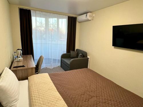 a hotel room with a bed and a chair and a television at Yavir in Poltava