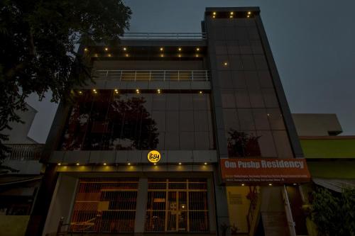 a building with a neon sign in front of it at Itsy By Treebo - Om Pushp Residency in Mathura