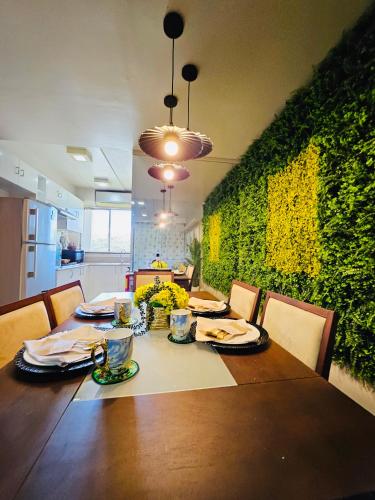 a dining room table with chairs and a green wall at Tropical Paradise @ One Oasis in Davao City+SM Davao in Davao City