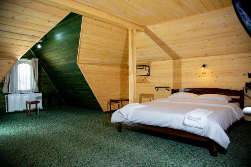 um quarto com uma cama num quarto de madeira em Casa Lulu em Dorna Cîndrenilor