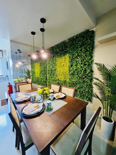 a dining room with a table and a green wall at Tropical Paradise @ One Oasis in Davao City+SM Davao in Davao City