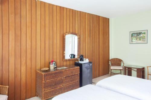 a bedroom with a wooden wall with a dresser and a mirror at Frenchman's Cove Resort in Port Antonio