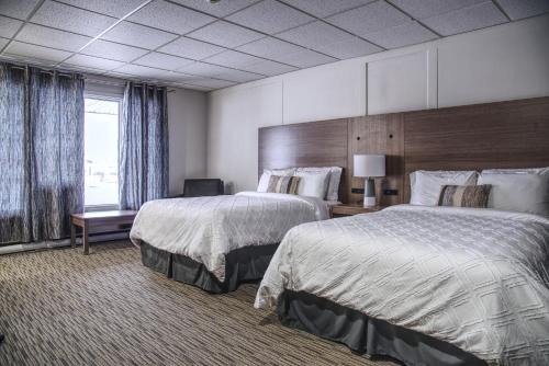 a hotel room with two beds and a window at Apollo Motel in Kapuskasing