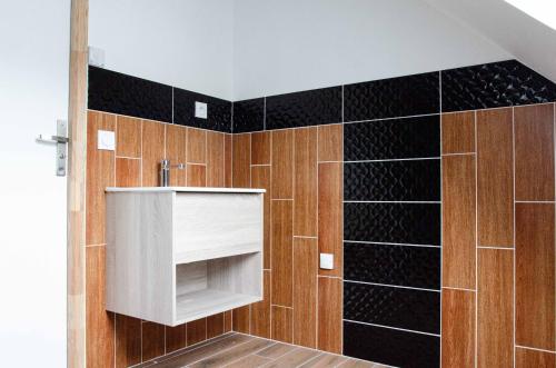 a bathroom with a sink and black tiles at Casa Adam's in Saint-Jean-le-Thomas