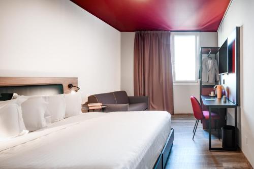 a hotel room with a bed and a desk at CX Venice Mestre in Mestre