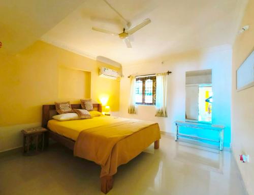 a bedroom with a large yellow bed in a room at Angels River Villa in Canacona