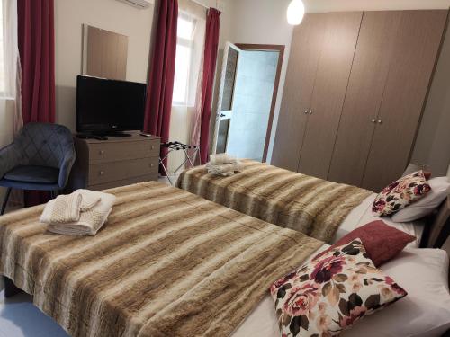 une chambre d'hôtel avec deux lits et une télévision dans l'établissement Waterside, à Birżebbuġa