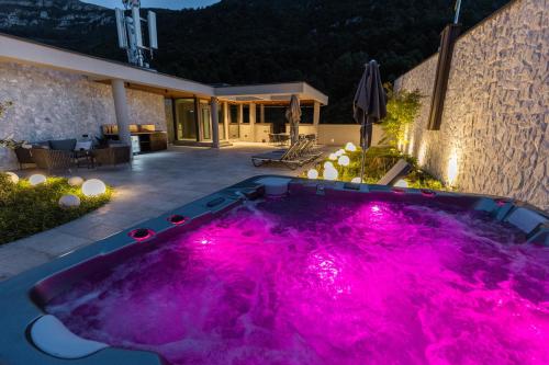 a hot tub with pink lighting in a backyard at Hotel Ramonda in Boljevac