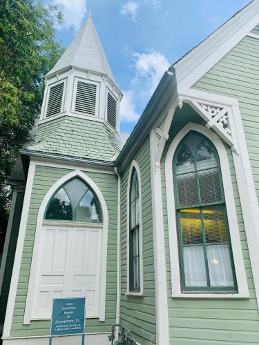 a green church with a white door and a tower at The Downtown Abbey in San Marcos