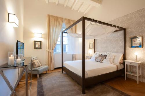 a bedroom with a canopy bed and a chair at Giotto Suite With View in Florence