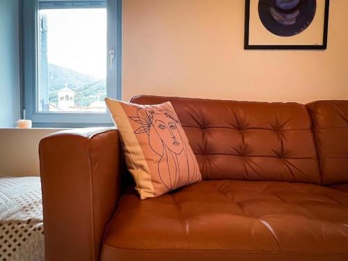 a brown leather couch with a pillow on it at Old Town Studios in Parga