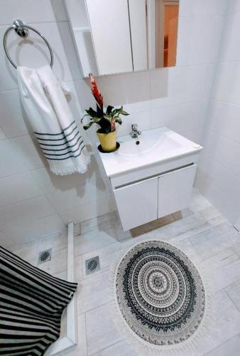 a white bathroom with a sink and a mirror at Old Town Studios in Parga