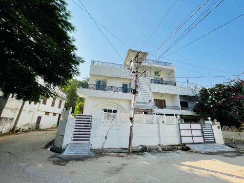 ein weißes Gebäude mit einer Treppe davor in der Unterkunft Krishna kottage A Boutique Home Stay in Udaipur