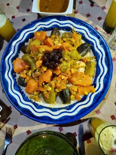 a blue plate of food on a table at Riad ma bonne étoile in Kasr Bounou