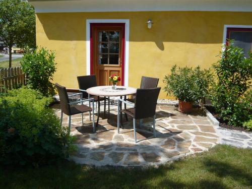 a patio with a table and chairs in front of a house at Landlust-Ferienhaus Am Rosenhof in Hartberg