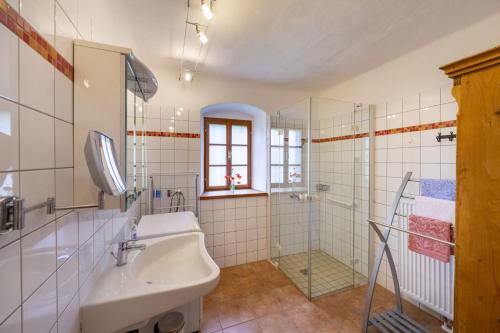 Baño blanco con lavabo y bañera en Landlust-Ferienhaus Am Rosenhof, en Hartberg