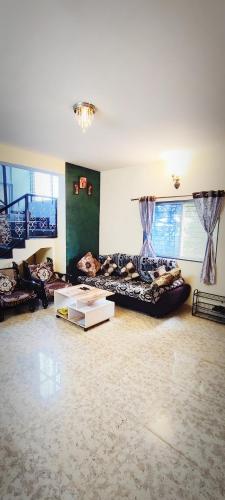 a large living room with couches and a table at Venus Villa in Panchgani