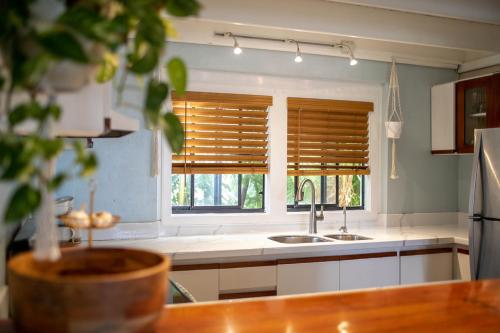 a kitchen with a sink and a window with blinds at Cruz Bay Tropical Condo in Bethany