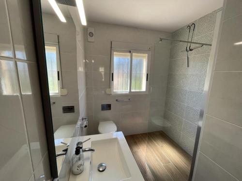 ein weißes Bad mit einem Waschbecken und einer Dusche in der Unterkunft Casa van Schaik in Albir