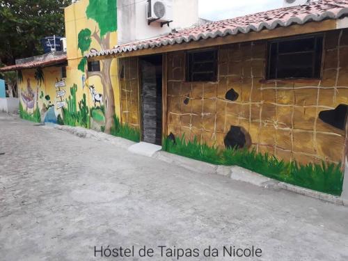 ein Gebäude mit Graffiti auf der Seite in der Unterkunft Pousada de Taipa da Nicole in Canindé de São Francisco