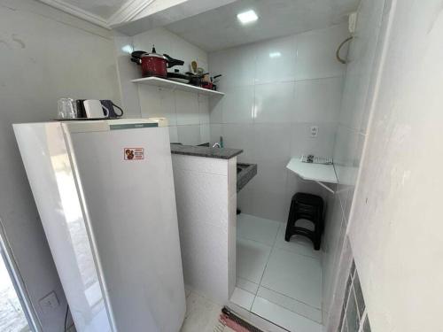 a small white kitchen with a refrigerator in it at Pousada de Taipa da Nicole in Canindé de São Francisco