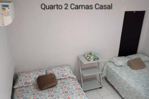 a small room with two beds and a table at Pousada de Taipa da Nicole in Canindé de São Francisco