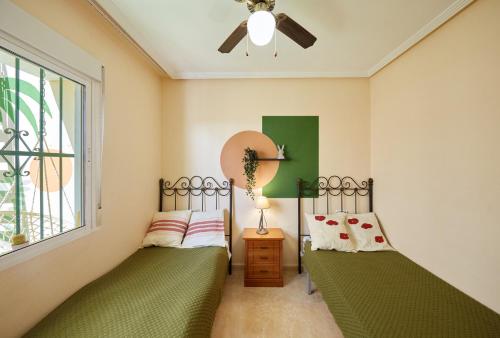 2 camas individuales en una habitación con ventana en Villa con vistas al mar en Alicante