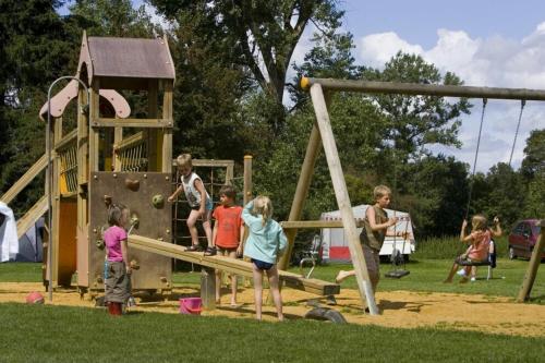 a group of children playing on a playground at Camping De Chênefleur in Tintigny